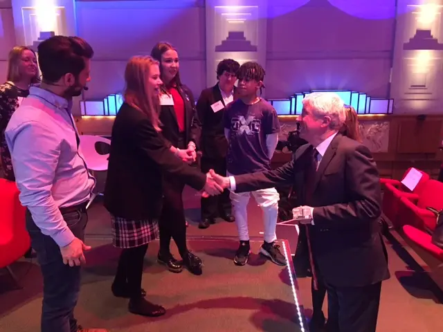 Tony Hall shaking hands with a teenage girl