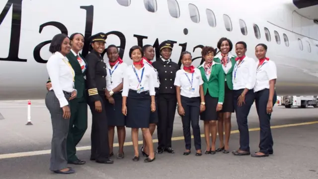 
          All female crew of Malawian airlines pose for a photograph outside the aircraft on the runway
        