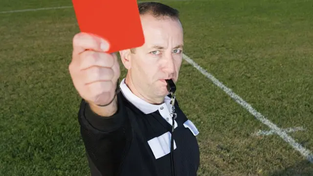 Referee holding up a red card