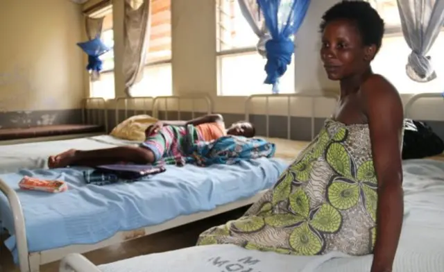 Malawian woman sits on a bed in maternity unit