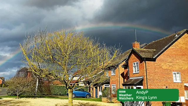 Rainbow in dark sky, over houses