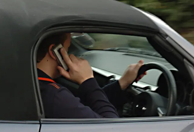 
          Undated file photo of a man using his mobile phone while driving. New drivers face losing their licence the first time they are caught using a phone behind the wheel illegally.
        