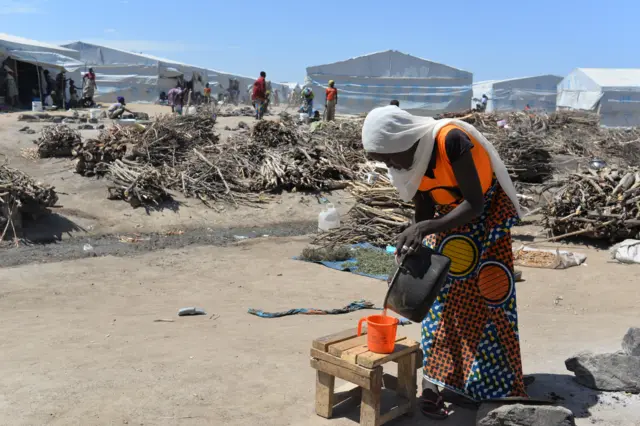 
          A woman works near piles of firewood on November 13, 2014 in a camp for Nigerian refugees in Minawao, in the extreme north-west of Cameroon
        