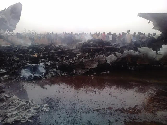 
          A picture taken on March 20, 2017 in South Sudan"s northwestern city of Wau shows people gathering near a plane wreckage after a jet crash-landed, leaving at least 37 people injured
        