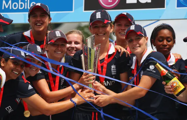 
          Charlotte Edwards of England lifts the trophy with team mates
        