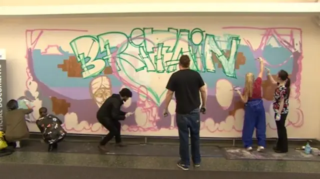 Volunteers painting the mural