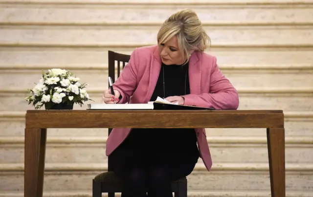 Michelle O'Neill signing the book of condolence