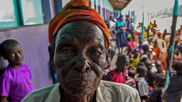 
          A woman poses as she arrives to watch on tv the screening of the start of the ICC (International Criminal Court) trial of former child soldier-turned-warlord Dominic Ongwen in Lukodi, Uganda
        