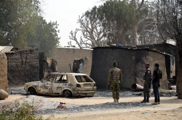 
          Soldiers looks at a burnt vehicle on February 4, 2016 during a visit to the village of Dalori village, some 12 kilometres from Borno state capital Maiduguri, northeastern Nigeria, after an attack by Boko Haram insurgents on the village left at least 85 people dead on January 30, 2016.
        