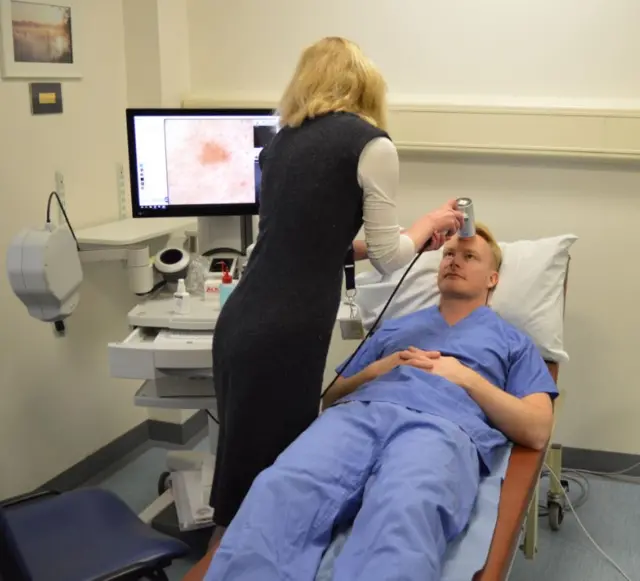 The microscope being tested on a member of hospital staff