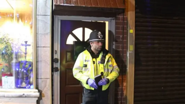 Police officer guarding door in Birmingham