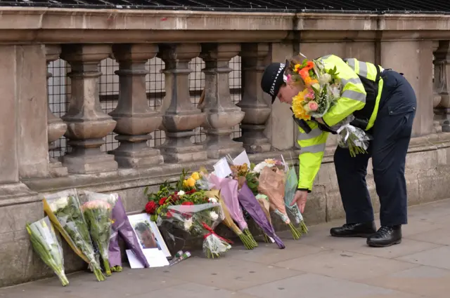 A policewoman leaves flowers