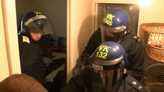 Three police officers in visors and helmets