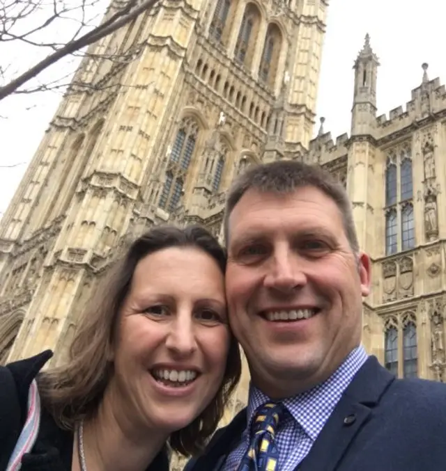 
          Michelle Evans and James Debbage stand outside the Palace of Westminster
        