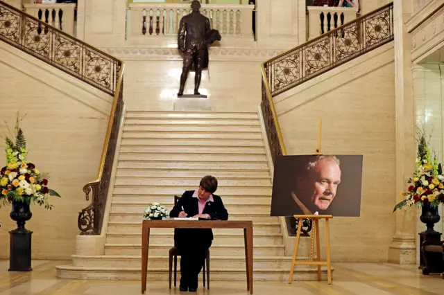 
          DUP leader Arlene Foster signs a book of condolence for Martin McGuinness at Stormont on 22 March 2017
        