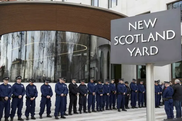 Police officers lay flowers at New Scotland Yard