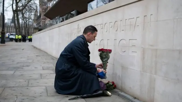 A man lays flowers