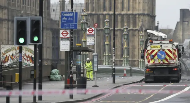 
          Cleaner sweeps Westminster Bridge with the Houses of Parliament in background
        