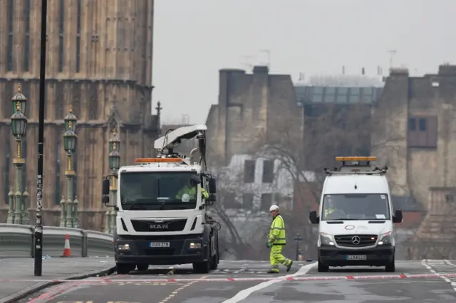 
          Workers clear debris on Westminster Bridge near the Houses of Parliament in central London
        