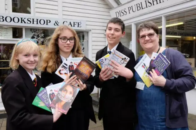 
          Pupils of the school with librarian Sharon Ellis, holding books
        