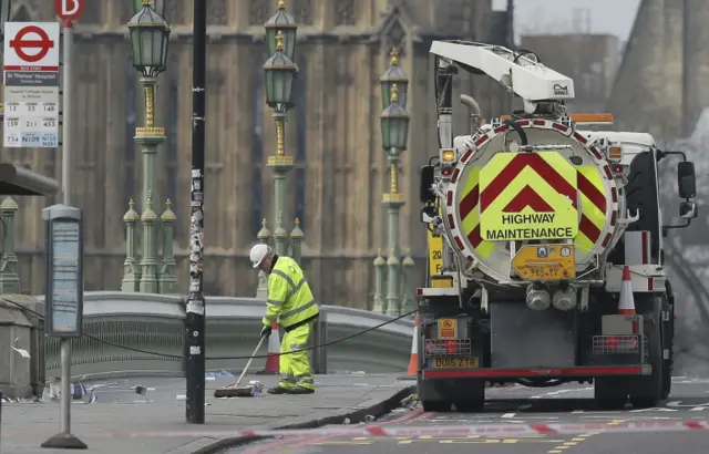 
          Cleaners sweep Westminster Bridge with the Houses of Parliament in background
        