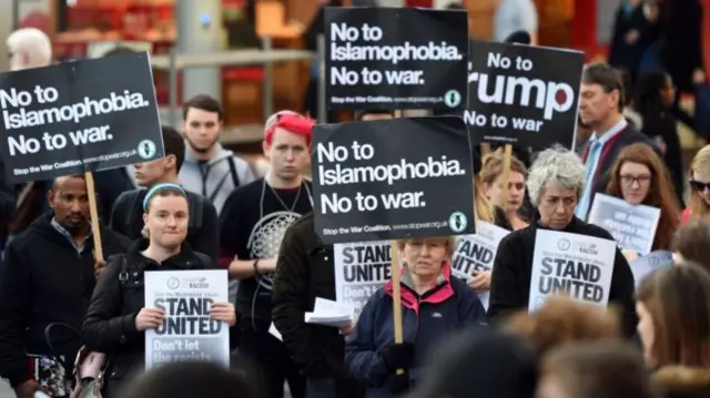 
          People hold placards during a vigil in Birmingham city centre
        