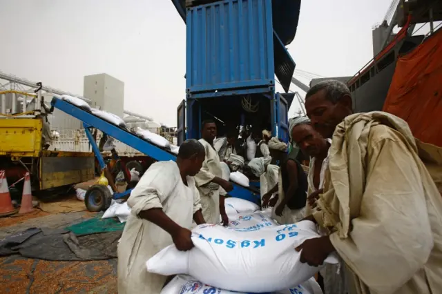 
          Sudanese workers offload US aid destined for South Sudan from the World Food Programme (WFP) at Port Sudan on March 19, 2017
        