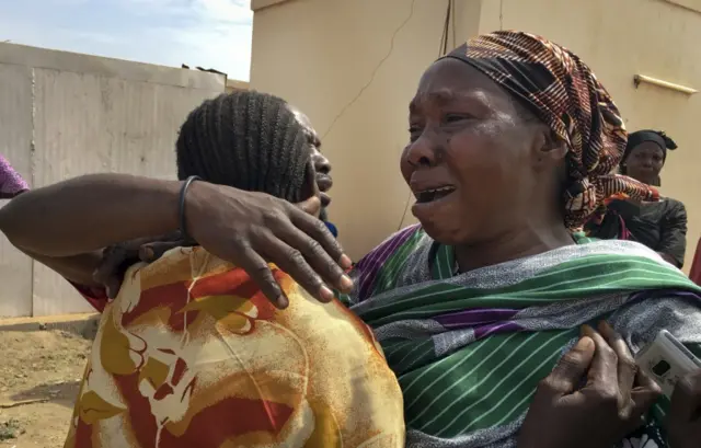 
          Relatives of the six aid workers who were ambushed and killed grieve as they wait to collect and bury the bodies of their loved ones, outside the morgue in Juba, South Sudan Monday, March 27, 2017.
        