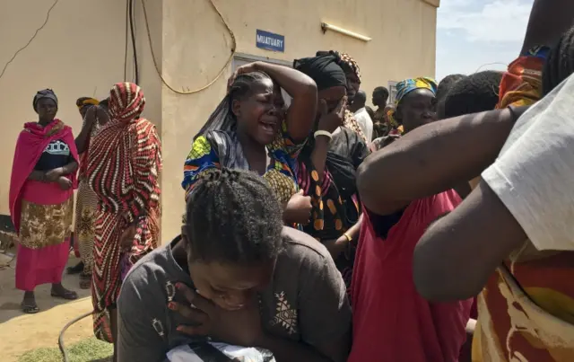 
          Relatives of the six aid workers who were ambushed and killed grieve as they wait to collect and bury the bodies of their loved ones, outside the morgue in Juba, South Sudan Monday, March 27, 2017.
        