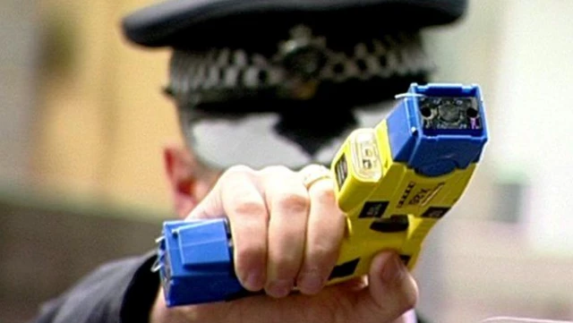 Police officer holding taser