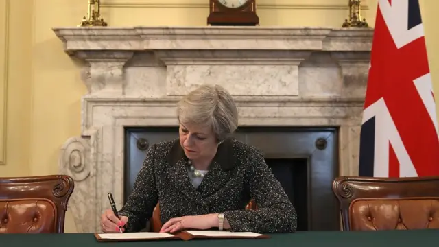 Theresa May signing the letter to trigger Article 50