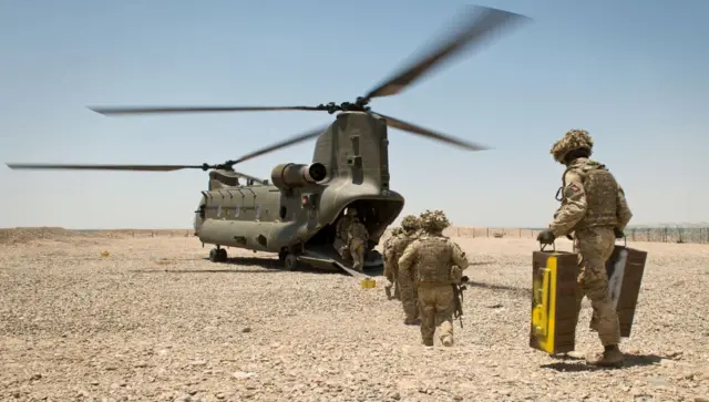 
          British troops withdrawal from Afghanistan in May 2014 - personnel walking towards a helicopter
        