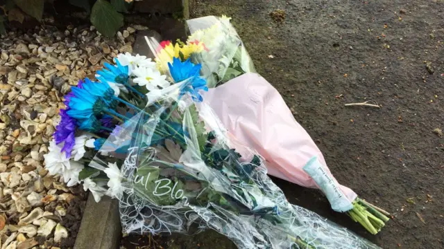 
          Flowers left outside house in Norton following the stabbing of three family members
        