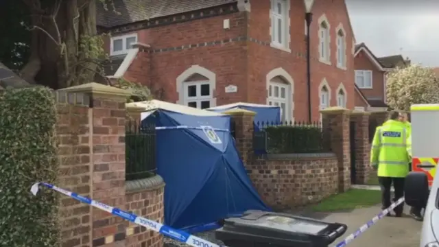 
          Police outside the Norton home where three family members were stabbed
        