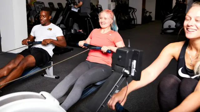 People doing indoor rowing at a gym