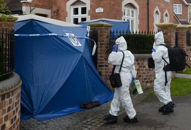 
          Police at the scene in Norton after a family of three were stabbed at their home
        