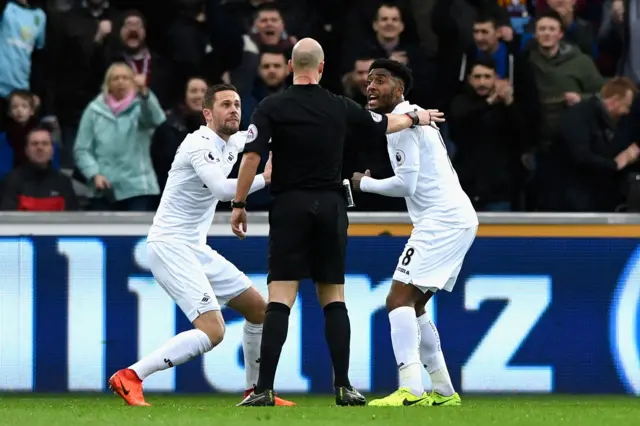 
          Gylfi Sigurdsson and Leroy Fer protest with referee Anthony Taylor over Burnley's penalty
        