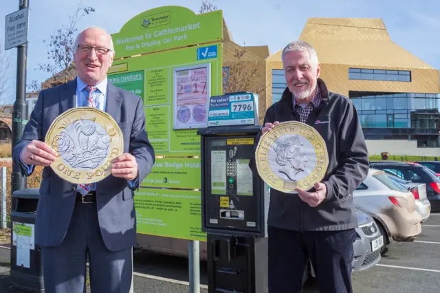 
          Andy Chinn, Parking & Enforcement Services Manager (L) and Cllr Geoff Williams (R), with enlarged replica copies of the new £1 coin
        