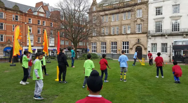 Children from Rushey Mead Academy playing cricket