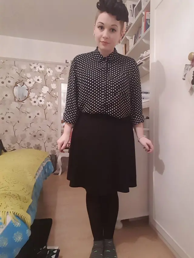 
          Rose Reilly in her interview outfit of black shirt with white polka dots, and a black skirt.
        