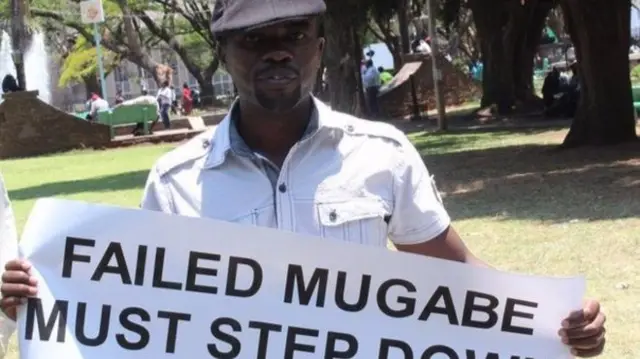 
          Itai Dzamara holds a sign saying "Failed Mugabe must step down"
        