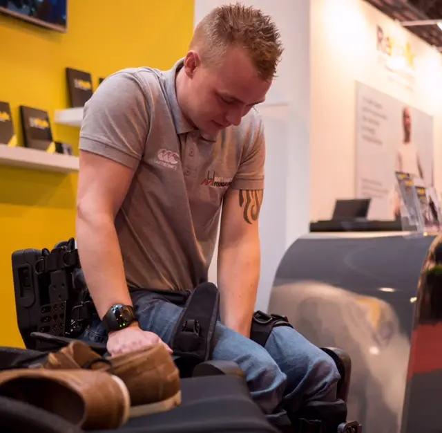 Spencer strapping on his robotic legs