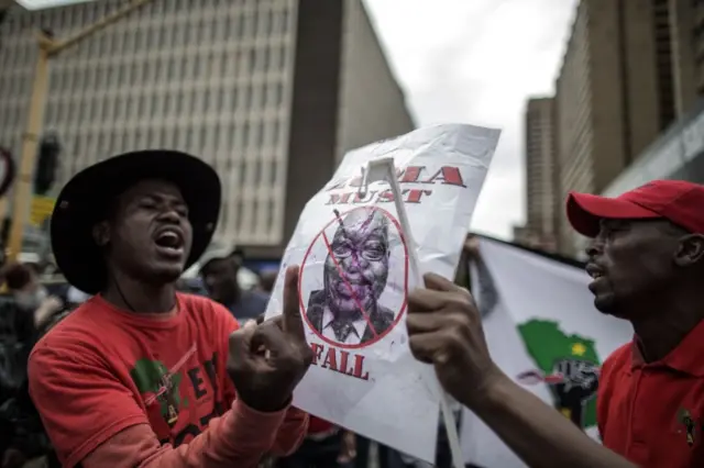 
          Protesters hold a portrait of South African president Jacob Zuma as thousands of South African took to the streets to demand the resignation of South African President Jacob Zuma, on April 7, 2017 in Pretoria, South Africa
        