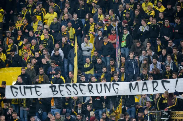 Fans hold a 'Get well soon' poster for Marc Bartra