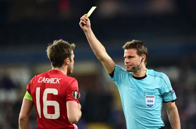 Michael Carrick is shown a yellow card