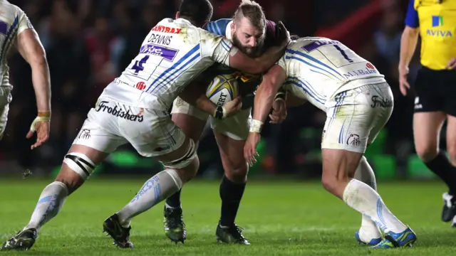 Joe Marler of Harlequins is tackled by Dave Dennis & Carl Rimmer of Exeter