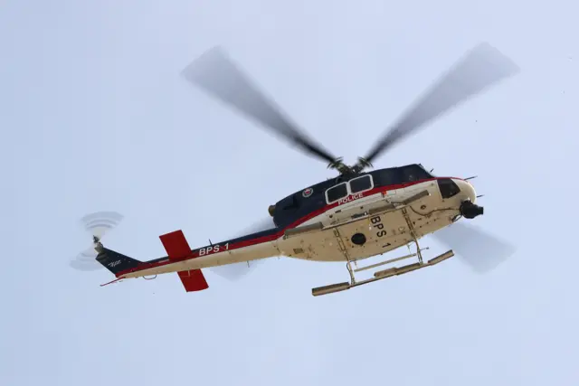 A police helicopter hovers above the circuit during final practice