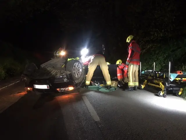 man being cut from overturned car