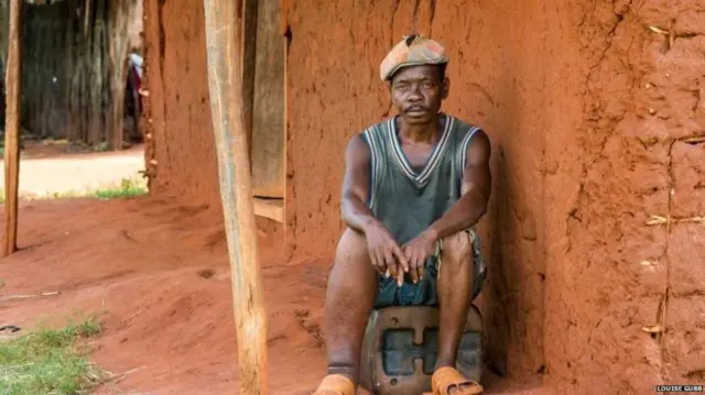 Man sitting in front of a house