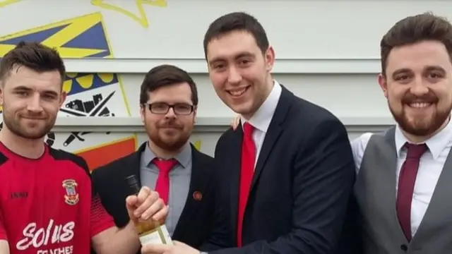 Sean Davey (right) is pictured with friends Graham Halliday (centre) and Craig Marnock presenting the man of the match award to Danny Newton (left)